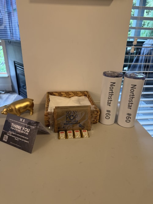 Welcome amenities on table in Northstar 60 Whistler apartment including Skinny Pop popcorn, Northstar tumblers, and WB