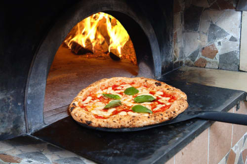 Pizza Margherita che cuoce in forno a legna presso CondHotel Vienna, Pesaro Italia