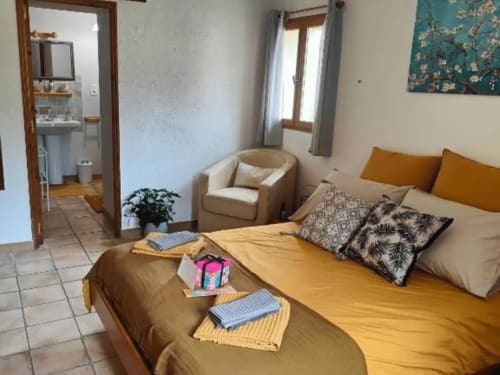 Gemütliches Gästezimmer auf dem Domaine Bellavigne mit zwei Einzelbetten, Sessel und eigenem Bad in Forcalquier