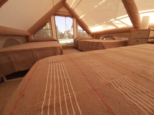 Interno spazioso della tenda familiare al Baia Dorica Camping Village con letti, travi in legno e luce naturale dai lucernari