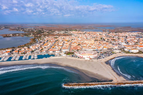 Aerial view of Aigues-Mortes coastal town with sandy beaches, marina, and Mediterranean waters