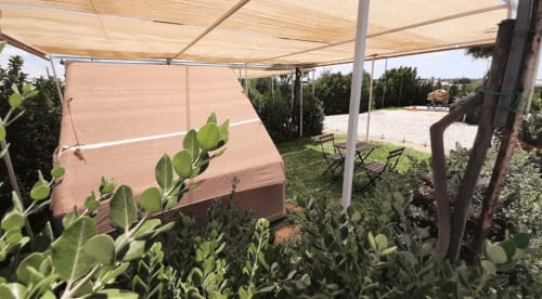 Alloggio in tenda ombreggiata al Baia Dorica Camping Village di Vittoria con sedute in patio e piante di fico d'India