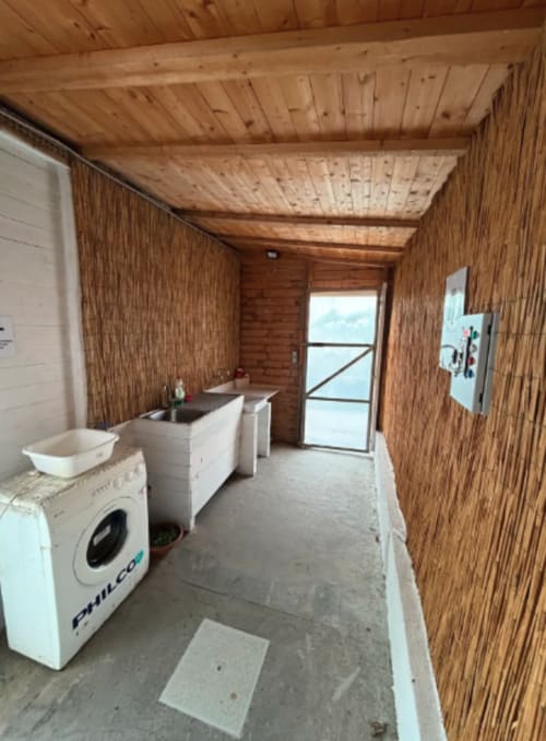 Buanderie du Baia Dorica Camping Village à Vittoria avec lave-linge, lavabo et intérieur en bois