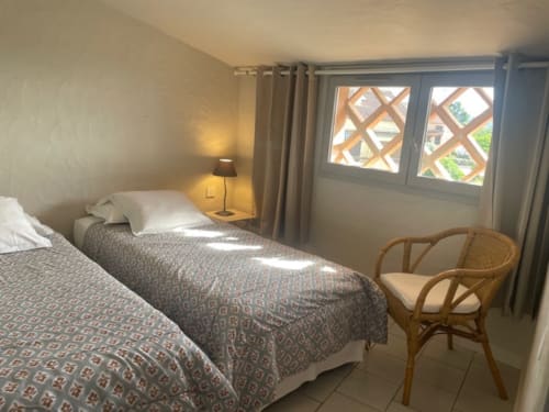 Chambre twin de l'Appartement N°5 à la Résidence Cala Di Sole, Lecci, avec vue sur mer et chaise en bois