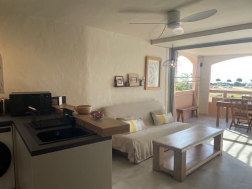 Appartement moderne à la Résidence Cala Di Sole à Lecci avec vue mer, séjour ouvert, cuisine et terrasse aménagée