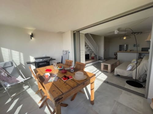 Lumineux studio ouvert à la Résidence Cala Di Sole à Lecci avec table à manger, kitchenette et accès à la chambre avec vue mer