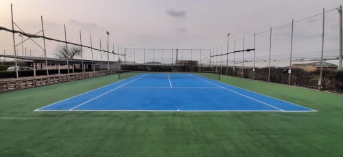 Campo da tennis blu con aree verdi presso il Camping Village Baia Dorica a Vittoria, Italia