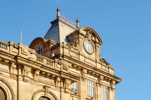 Historic clock tower of Campanhã Boutique Station in Porto, Portugal against clear blue sky