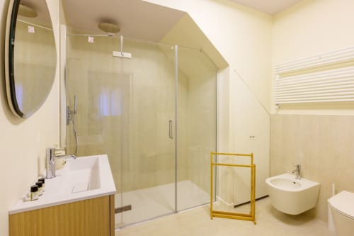 Modern bathroom in Bealux villa, Venice with walk-in shower, floating sink, bidet, and heated towel rack