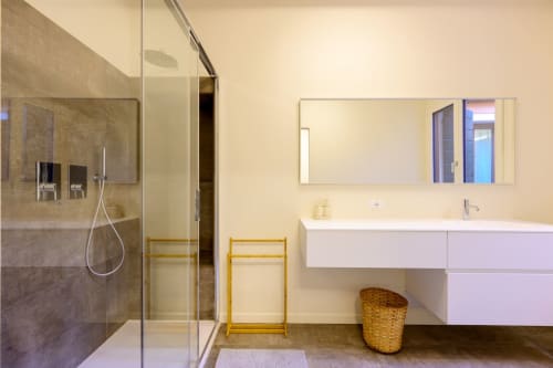 Modern bathroom in San Vio villa, Venice with glass shower, white vanity, and heated towel rack