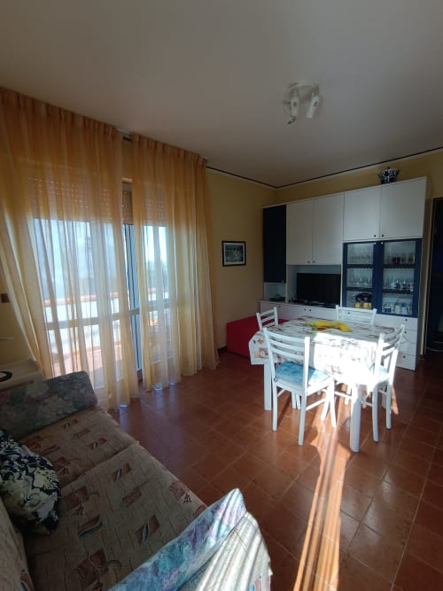 Luminosa sala da pranzo a Tales of Abruzzo con tavolo, divano e vista sulla terrazza ad Atessa