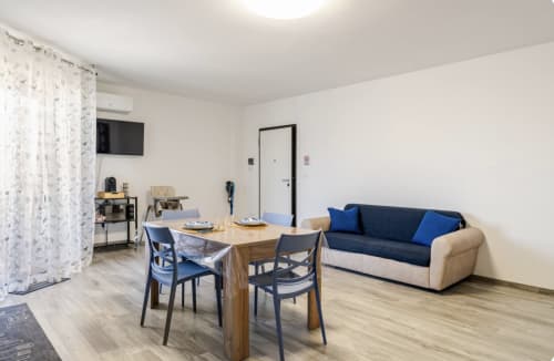 Appartamento Brindisi Comfort House con tavolo da pranzo, divano blu navy, angolo cottura e arredi moderni