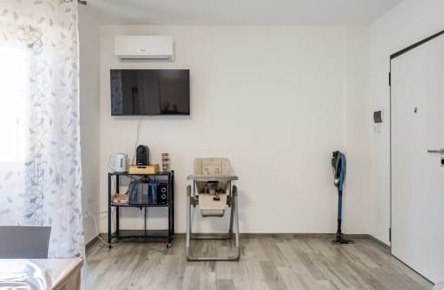 Moderno soggiorno in appartamento a Brindisi con TV a parete, aria condizionata, angolo cottura, seggiolone e accessibile
