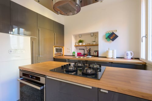 Cuisine moderne dans l'appartement vénitien Bealux avec plans de travail en bois, cuisinière au gaz et électroménagers en acier inoxydable