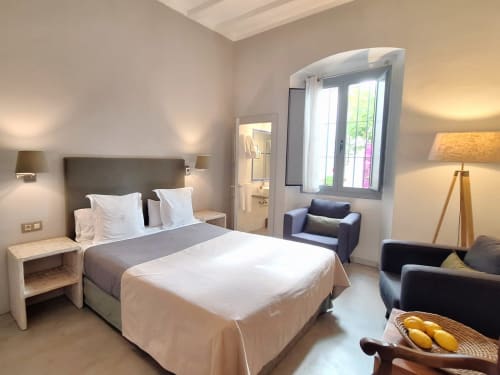 Chambre moderne de l'hôtel Casa Calella à Calella de Palafrugell avec lit queen-size, coin salon et vue sur le jardin