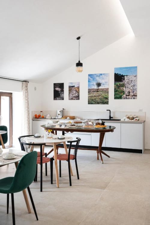 Zona cucina e pranzo moderna di AgriBio Villa Ribes ad Altamura con opere d'arte paesaggistica e mobili mid-century