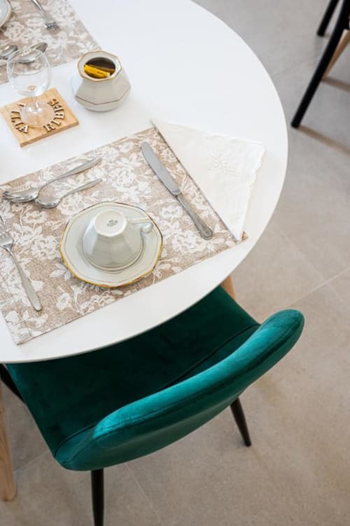 Elegante tavolo ad AgriBio Villa Ribes con sedia turchese, piatto bianco su tovaglietta patterned e Altamura