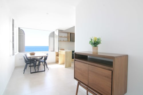 Modern studio apartment in Calpe with sea view, wooden TV unit, dining table, open kitchen, and blue Mediterranean vista from