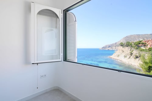 Modern apartment balcony at Riurau Home in Calpe with sea view of Mediterranean coastline and open window with shade