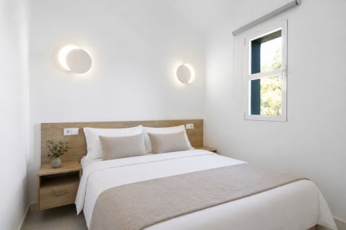Bright bedroom in Xanadú apartment at Riurau Home, Calpe with sea view, wooden headboard, white bedding and modern lighting