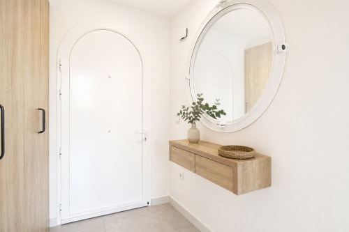 Modern bathroom at Riurau Home Calpe with arched mirror, wooden vanity, and rainfall shower