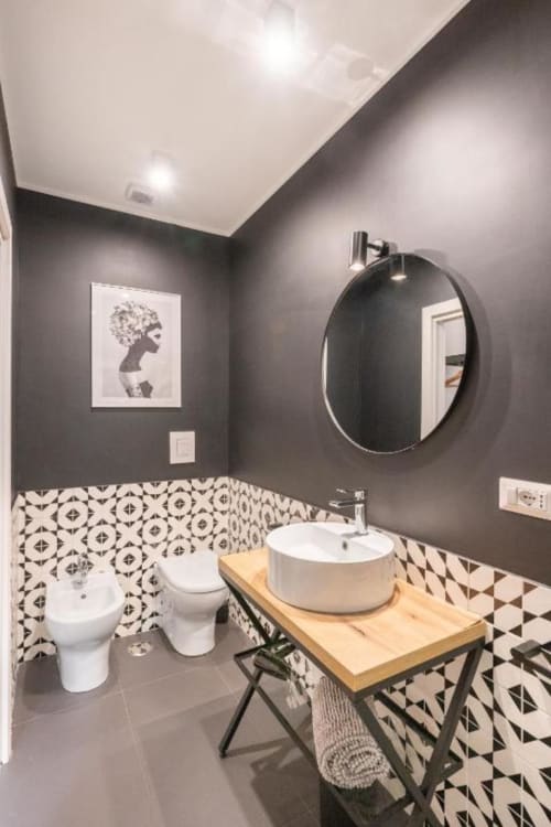 Modern bathroom in Suite Maradona Naples with patterned tile accents, round mirror, vessel sink, toilet, and bidet