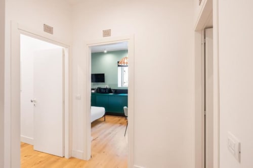 Hallway in Suite Maradona Naples with open doors leading to kitchenette and bedroom with teal accents