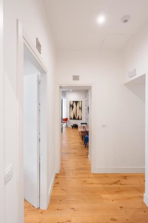 Bright hallway in Suite Maradona Deluxe Double Room in Naples, leading to living area with wooden floors and modern white