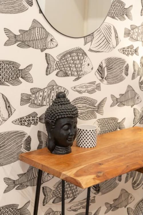 Deluxe room at Suite Maradona Naples featuring wooden desk with black Buddha head sculpture and polka dot mug against