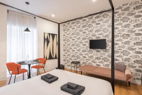 Deluxe Double Room at Suite Maradona Naples with canopy bed, fish-patterned wallpaper, and modern furnishings