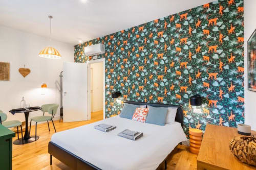 Modern Superior Double Room at Suite Maradona Naples with jungle-patterned accent wall, wooden floors, and contemporary