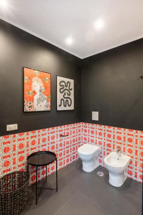 Modern bathroom at Suite Maradona Naples with red patterned tiles, dark walls, white fixtures, and contemporary art in a