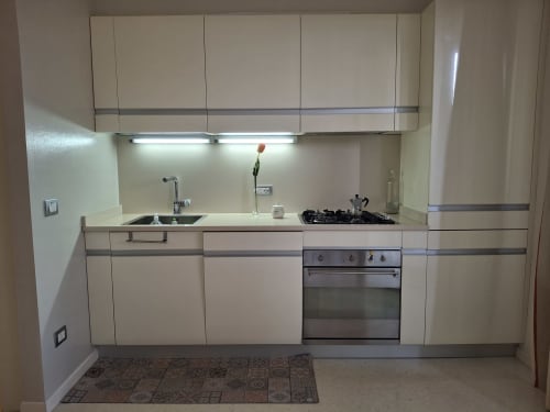 Angolo cottura moderno dell'hotel Prince Garda a Serniga con mobili color crema, forno in acciaio inox e piano cottura a gas