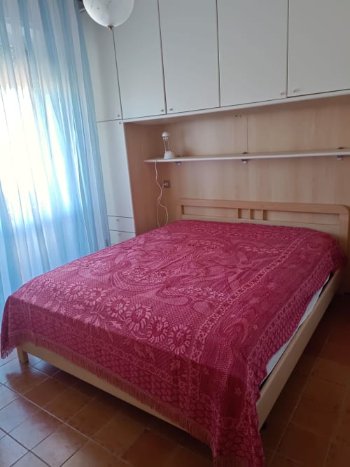 Spaziosa camera da letto a Tales of Abruzzo, Atessa - letto in legno con biancheria borgogna, mobili bianchi, finestre luminose