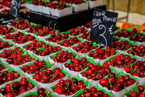 Cerises rouges fraîches dans des bacs blancs au marché de Forcalquier, à 3€