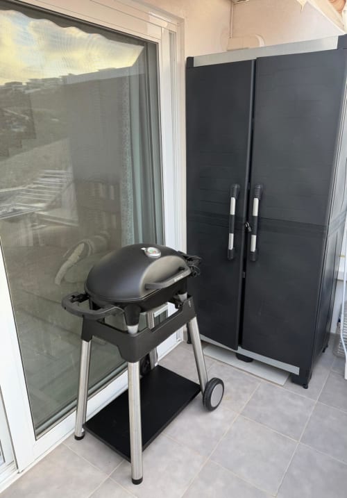 Black electric grill and storage cabinet on balcony at Costa Adeje apartment with sea view