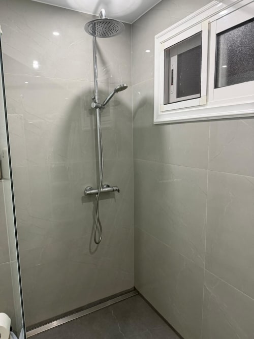 Modern shower enclosure with rainfall showerhead and hand shower in Costa Adeje apartment bathroom