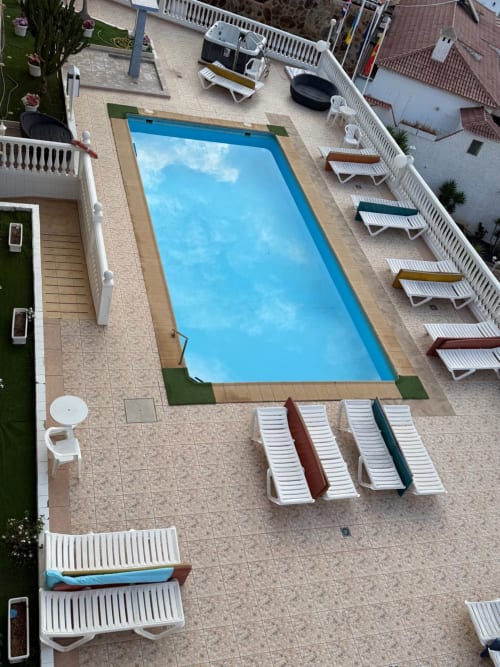 Aerial view of rectangular swimming pool with loungers at Costa Adeje apartment complex near Siam Park, Tenerife