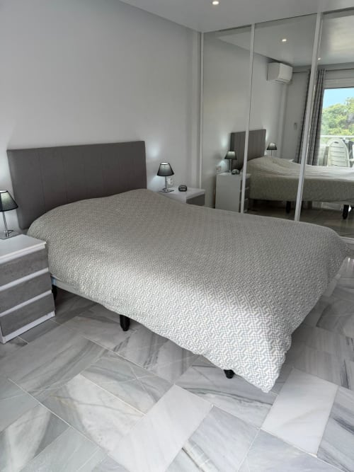 Modern bedroom with queen bed, dark headboard, and mirrored wardrobe in Costa Adeje apartment near Siam Park