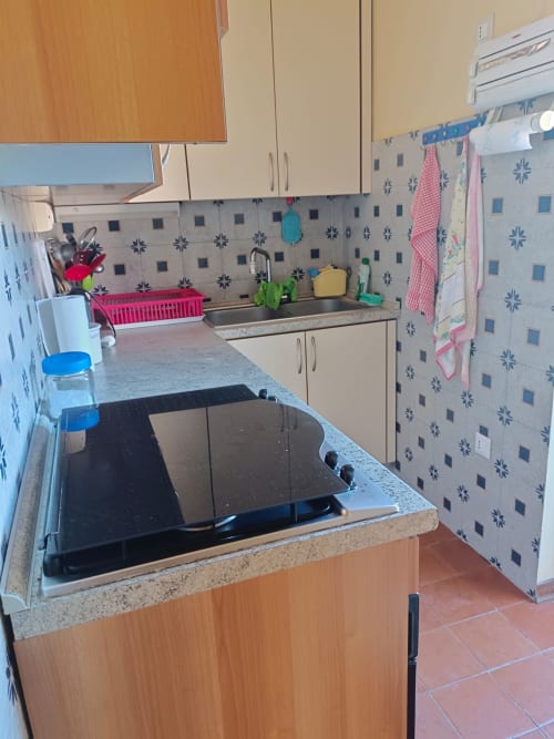 Cucina moderna con piano cottura elettrico, lavello in acciaio inox e piastrelle decorate nell'appartamento Bellavista Levante a Tales of
