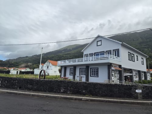Inn Nature hotel in São Roque do Pico, Açores - white building with blue accents and terrace overlooking green hillside