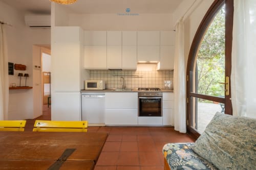 Moderna cucina bianca con cucina a gas e zona pranzo in Villa Chia, House Live Express, Quartu Sant'elena