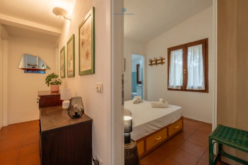 Camera moderna a Villa Chia presso House Live Express, Quartu Sant'Elena, con letto in legno, biancheria bianca e vista sul giardino