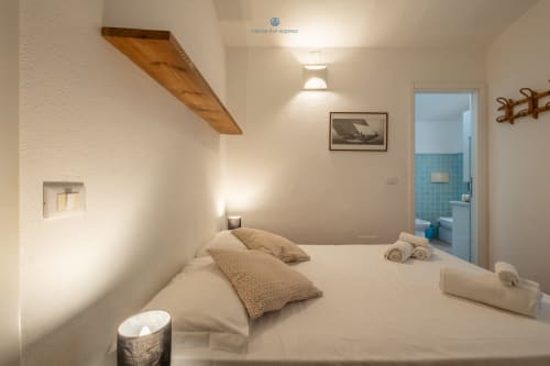 Camera luminosa in Villa Chia presso House Live Express con letto matrimoniale, bagno en-suite, ripiano in legno e vista sul giardino