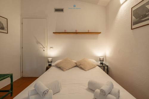 Camera da letto accogliente della villa House Live Express a Quartu Sant'Elena con biancheria bianca, cuscini e asciugamani arrotolati