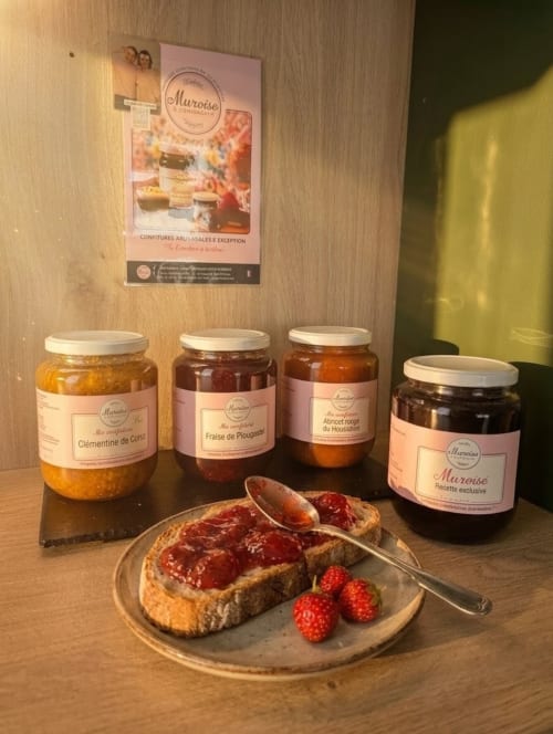Pots de confiture Muroise présentés à l'hôtel La Verriaire avec du pain grillé frais et des baies
