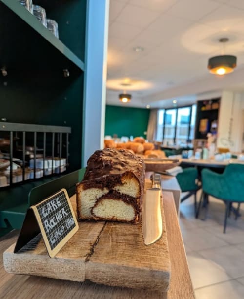 Tranche de cake marbré sur plateau en bois au salon de l'hôtel La Verriaire à Chanverrie, France