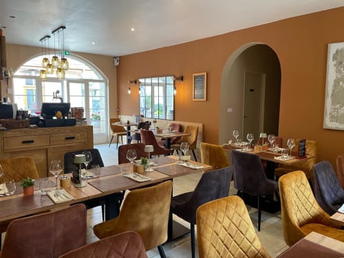 Elegant dining room at Clos De La Gourmandiere B&B in Saint-Lothain with gold chairs, warm orange walls, and fine table