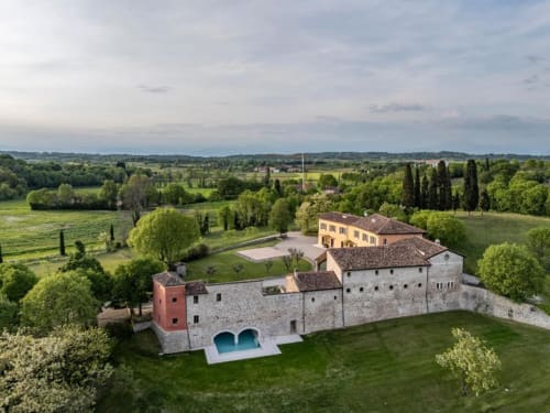 Corte Baruzzo Relais, un'elegante dimora storica in pietra con villa gialla a Volta Mantovana, circondata da lussureggianti giardini