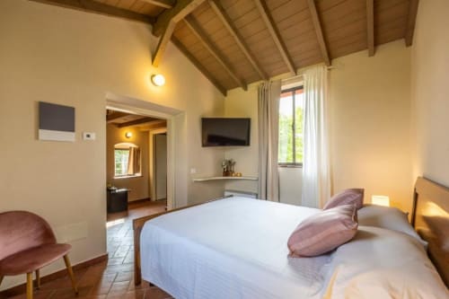 Camera Tripla Superiore a Corte Baruzzo Relais con letto, TV a schermo piatto, vista sul giardino e travi a vista